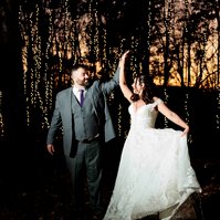 man and woman dancing outdoors at night with sunset and string lights