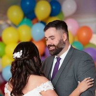 man and woman dancing with balloons in background