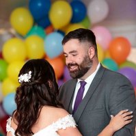man and woman dancing with balloons in background