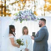 bride and groom with officiant man reading vows