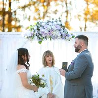 bride and groom with officiant man reading vows
