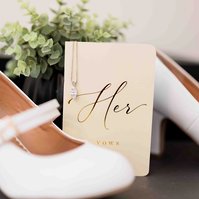 white wedding shoes and vow book that read "her" and necklace