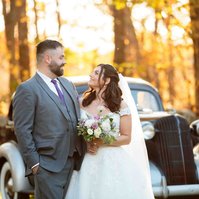 man and woman looking at each other in front of old car