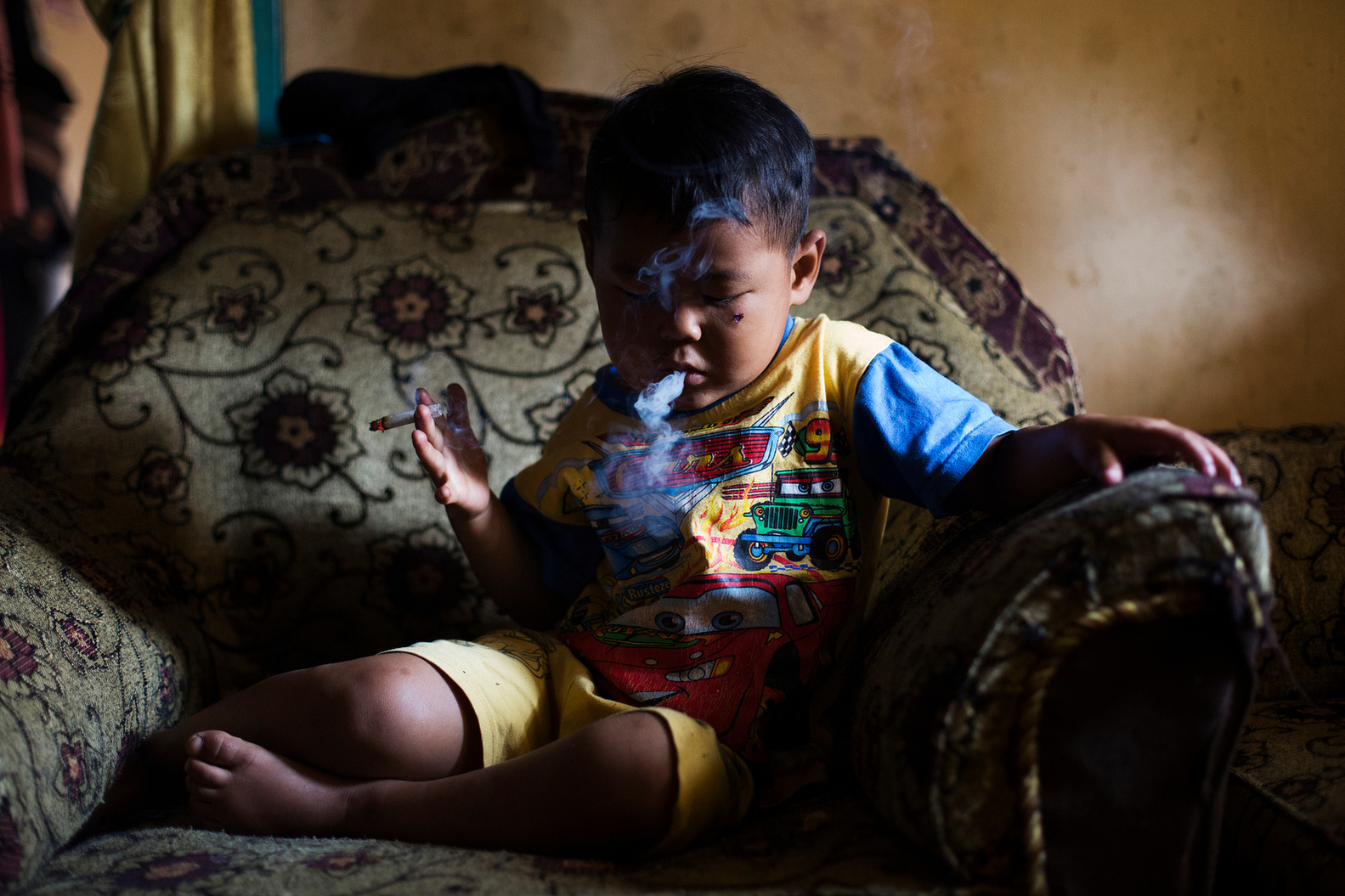 Five-year-old Ardian Azka Mubarok smokes at his home in Garut, Indonesia on March 27, 2015. (Photo By: Michelle Siu)