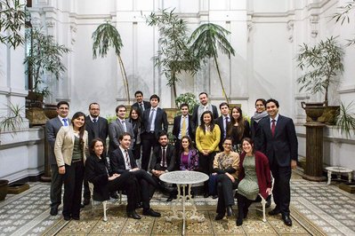 A group of people pose for a photograph inside a white building 