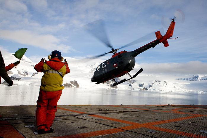 Helicopter flying over Antarctica, boat, cargo, coast, commerce, container, crane, dock, export, forms, harbor, high, industrial, industry, line, loading, ocean, outdoors, over, perspective, port, sea, ship, heliport, heli