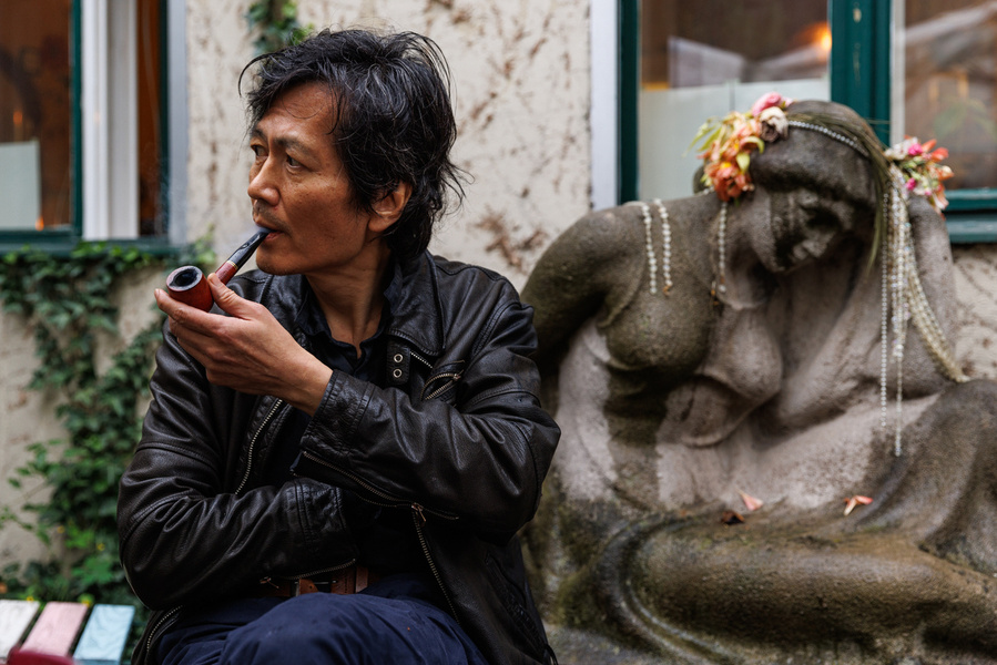 Portrait of Philosopher Byung-Chul Han smoking a pipe in a Berlin cemetery, for el Pais Semanal magazine