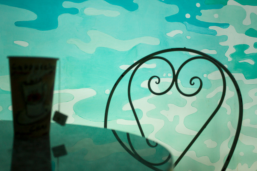 Detail of a tea cup with blue sea water behind.