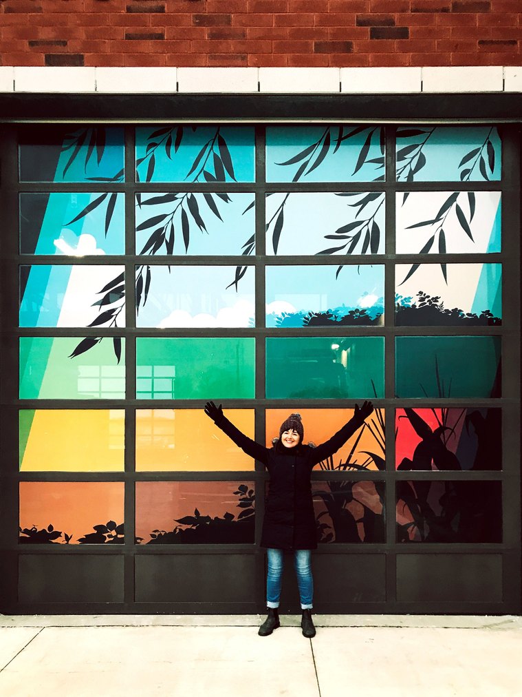 Pam Lostracco stands in front of one of the fire station's garage doors that feature a mural of horses and the local countryside. 