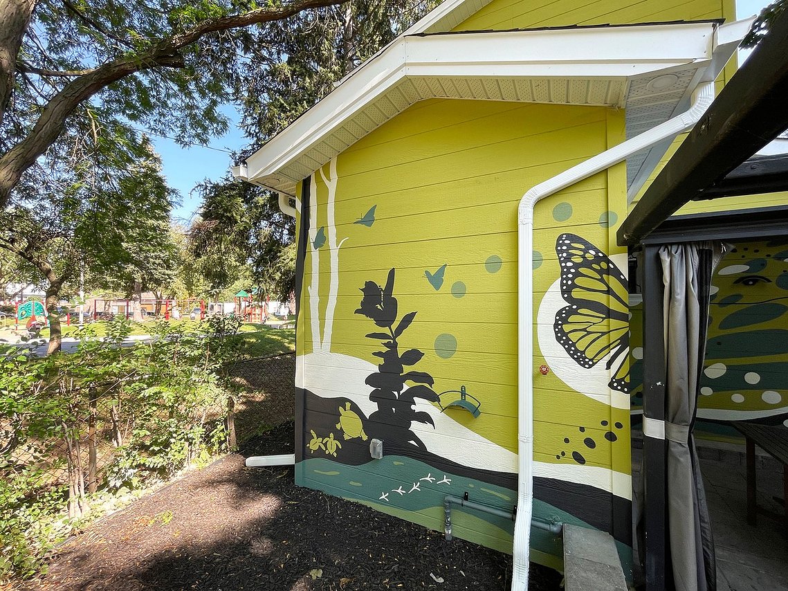 A monarch butterfly wing with a rolling landscape continuing across all the walls with turtles and milkweed. 
