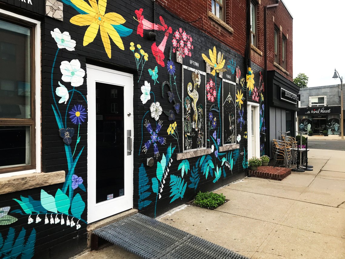 Side view of the cafe's floral mural filled with Soloman's seal, ferns, and sunflowers that can be viewed from Yonge Street. 