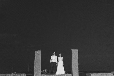 black and white couple portrait bride and groom standing between stone columns on their wedding day in Milwaukee, Wisconsin at South Shore Terrace