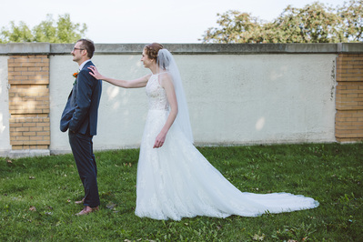 first look photograph for bride and groom on their wedding day at south shore terrace in milwaukee, wisconsin.  the bride is tapping on the grooms shoulder as he faces away from her.