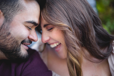 Milwaukee engagement photography session in the Riverwest neighborhood.  couple's foreheads are touching, as they smile and laugh.  color photograph.