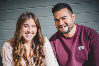 Milwaukee engagement photography session in the Riverwest neighborhood.  Couple smiling while looking at the camera.