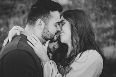 Milwaukee engagement photography session in the Riverwest neighborhood.  Couple are about to kiss, smiling at one another.  Photograph is in black and white.