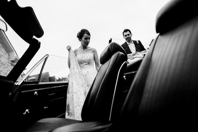 soon to be married couple getting into a classic car in black and white.