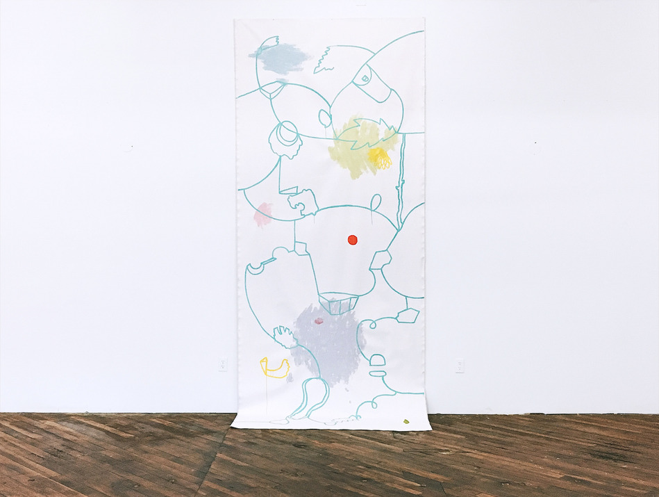 Long, hanging roll of canvas against wall with painted lines and colors. Touches wooden floor.