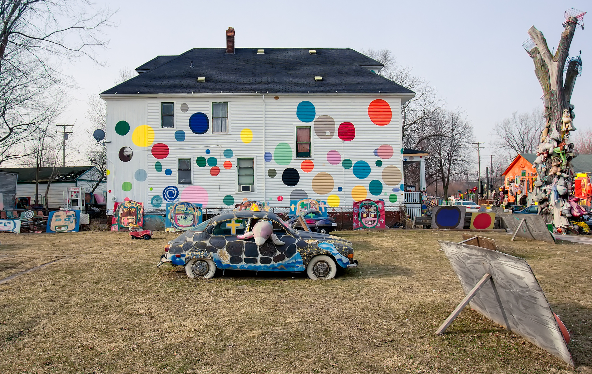 Immerse yourself in Tyree Guyton's visionary art at The Heidelberg Project in Detroit, MI. Discover the enchanting scene with a turtle-painted car, complemented by a dolphin inside. The iconic Polka Dot House.