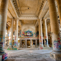 Abandoned Ford Michigan Central Station in Detroit, Michigan, ornate architectural details and numerous columns stand amidst vibrant graffiti, creating a unique juxtaposition of decay and creativity