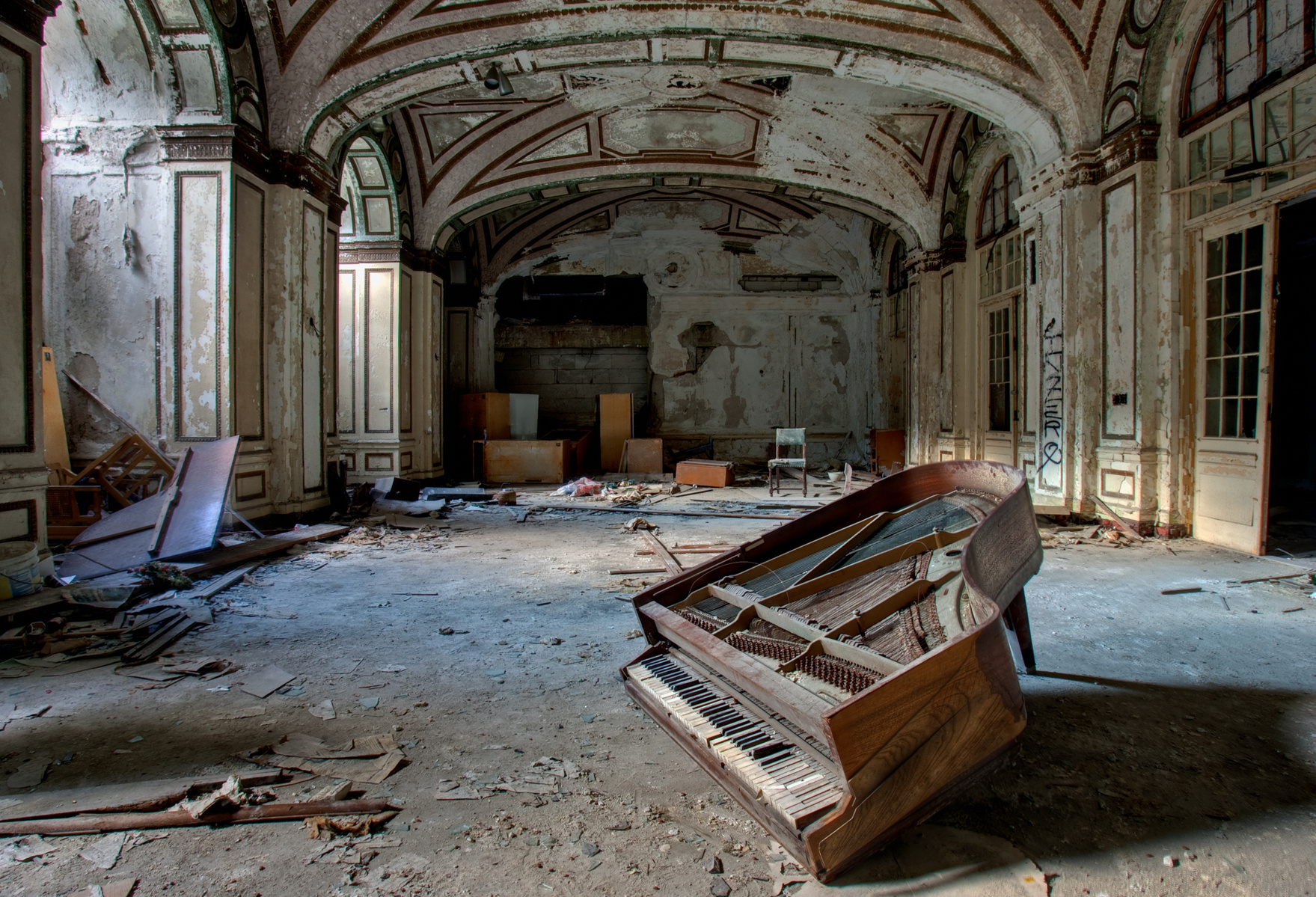 Step into the haunting beauty of Lee Plaza, an abandoned building in Detroit, MI. Witness a baby grand piano, leaning on its last leg, as streaks of light create an ethereal atmosphere from left to right. Explore the forgotten allure of decay in Lee Plaza