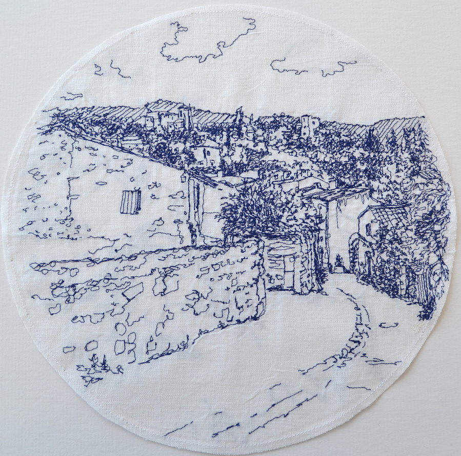 saskia linen stitched drawing with thread village of Oppede hillside view with houses and cobbled street ahead, original embroidery stitch-sketch blue thread on white linen fabric within circle
