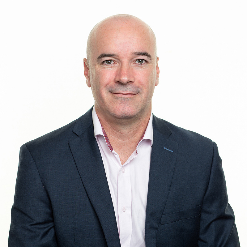 Professional corporate headshot of a business professional on a white background