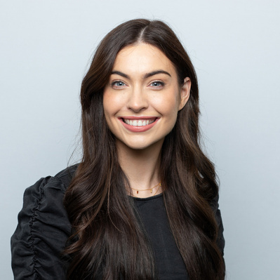 Professional corporate headshot of a business professional on a grey background