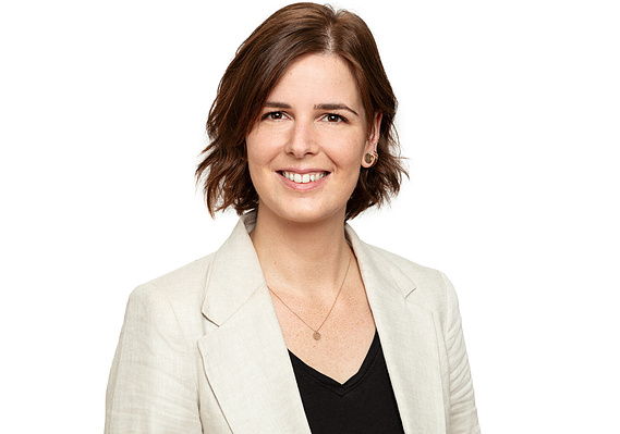 A professional business headshot portrait taken onsite using a studio setup in an office environment
