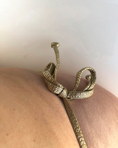 A golden string bikini string tied in a bow around my seated ass.