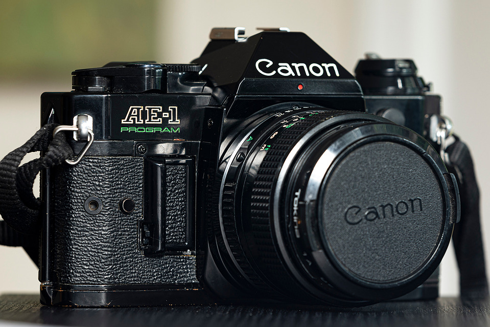 A front-angled shot of the Canon AE-1 Program with a Tokina 28mm f/2.8 FD lens, emphasising its vintage aesthetic and balanced proportions.