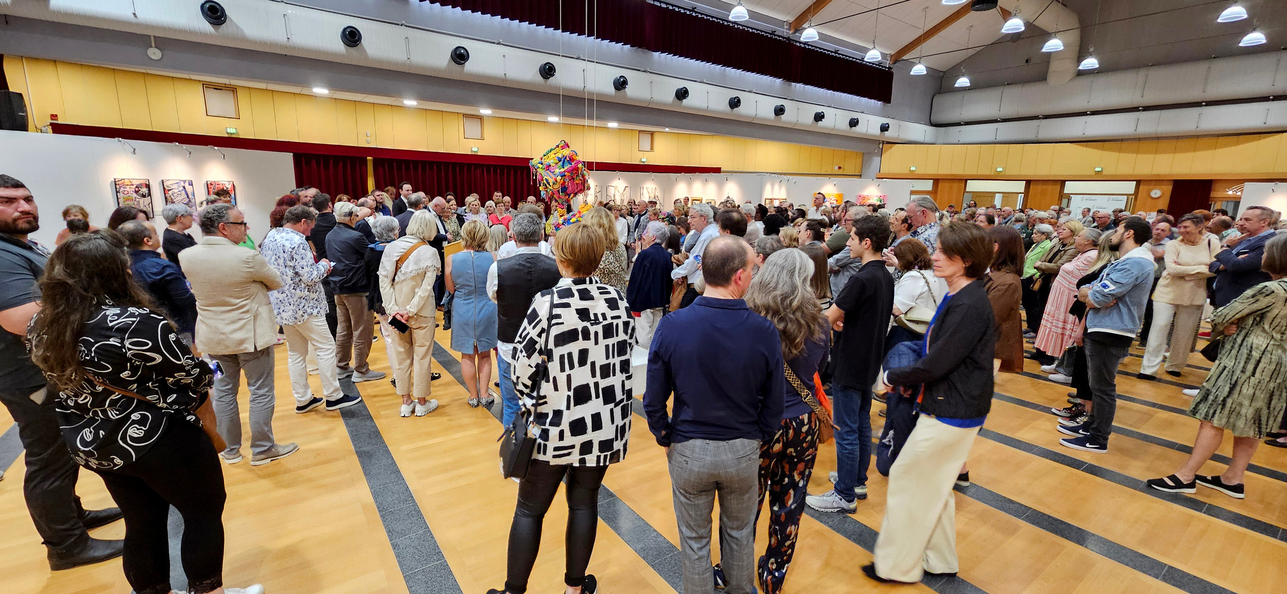 Crowd of people at the opening of the 12h bienniale of Contemporary art in Strassen, Luxembourg, exhibition hall. 