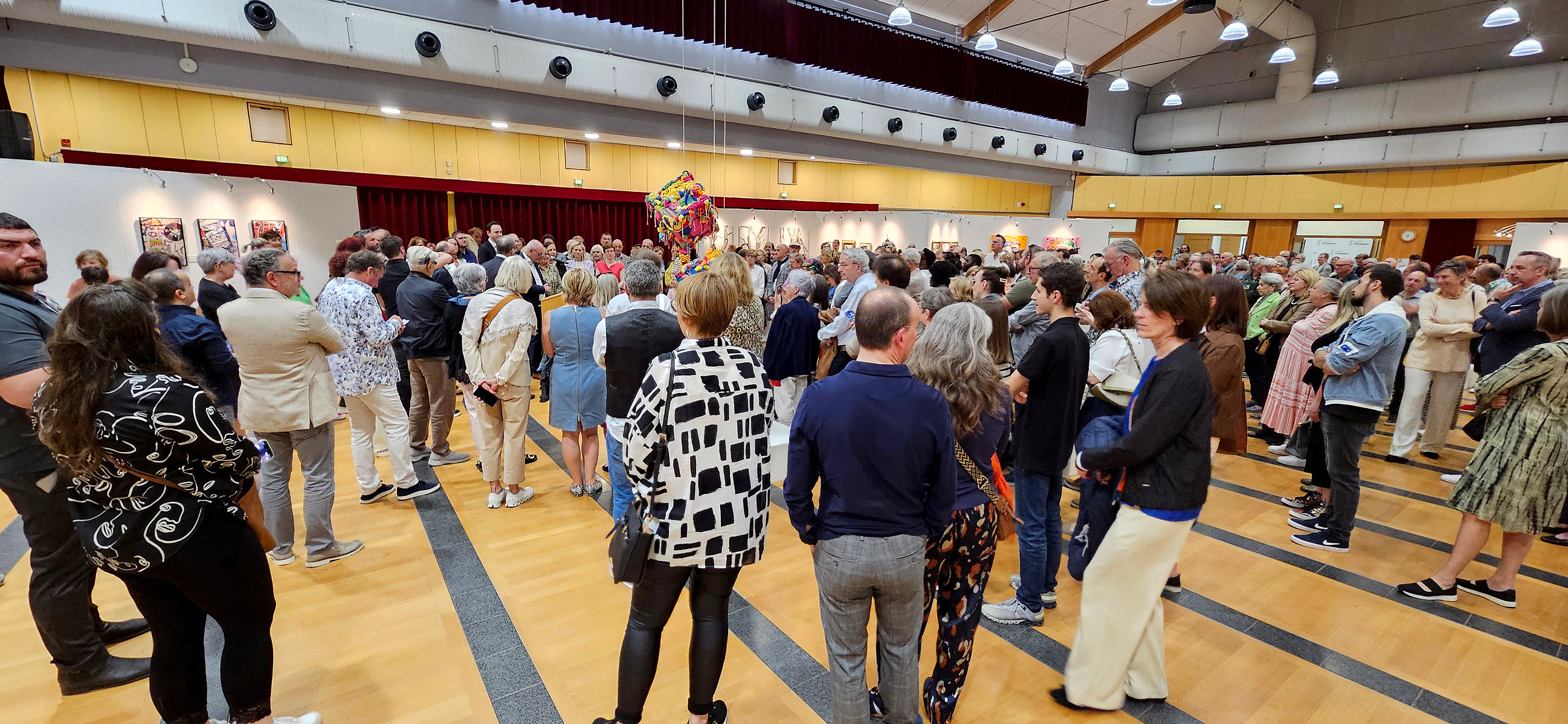 Crowd of people at the opening of the 12h bienniale of Contemporary art in Strassen, Luxembourg, exhibition hall. 