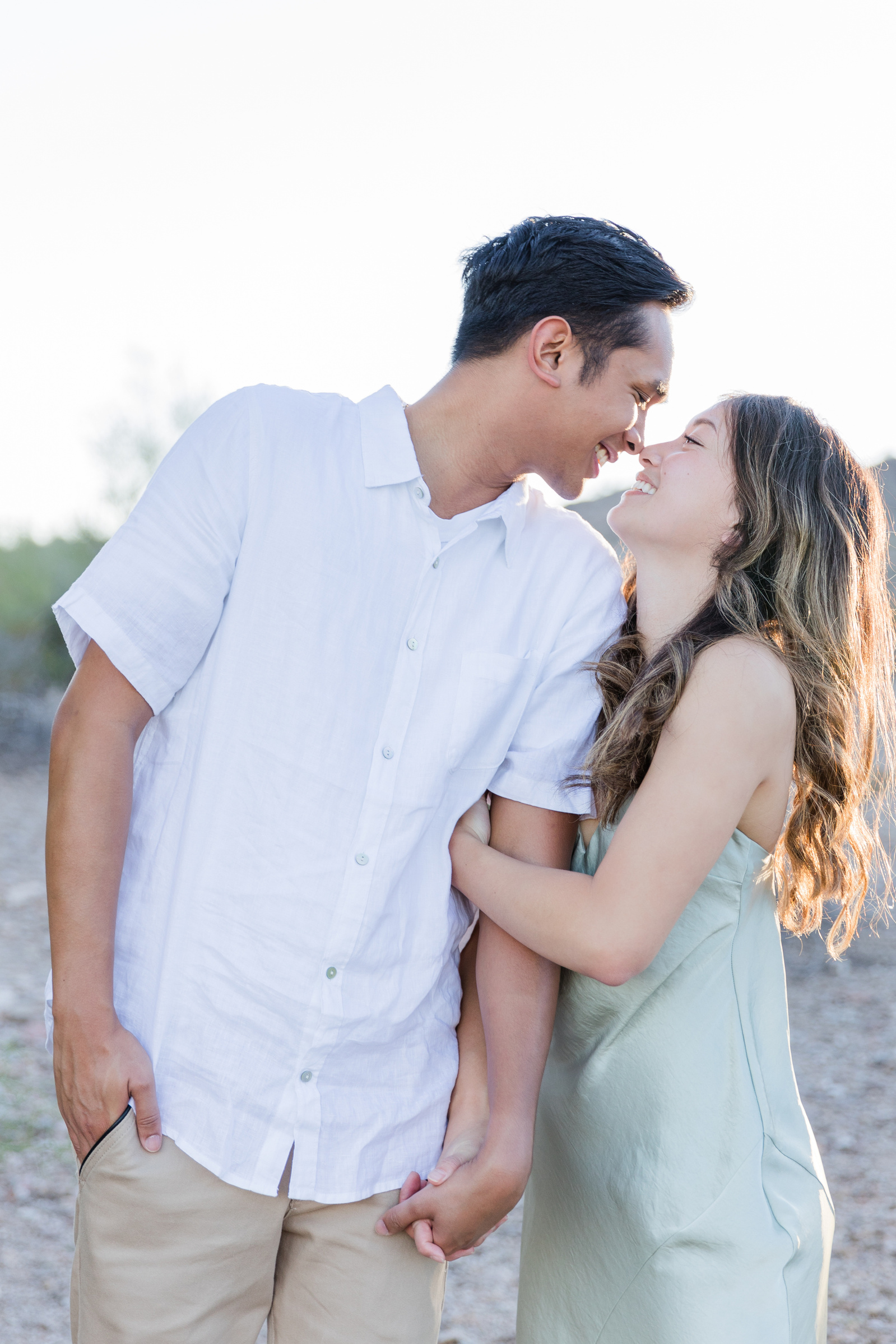 Two people take engagement photos in the Arizona desert