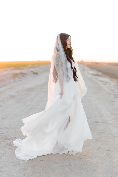 Woman wearing bridal gown in a farm field. Phoenix Arizona