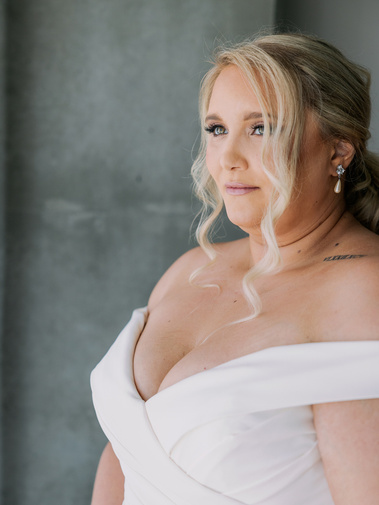 A woman looking out the window of her hotel room on her wedding day