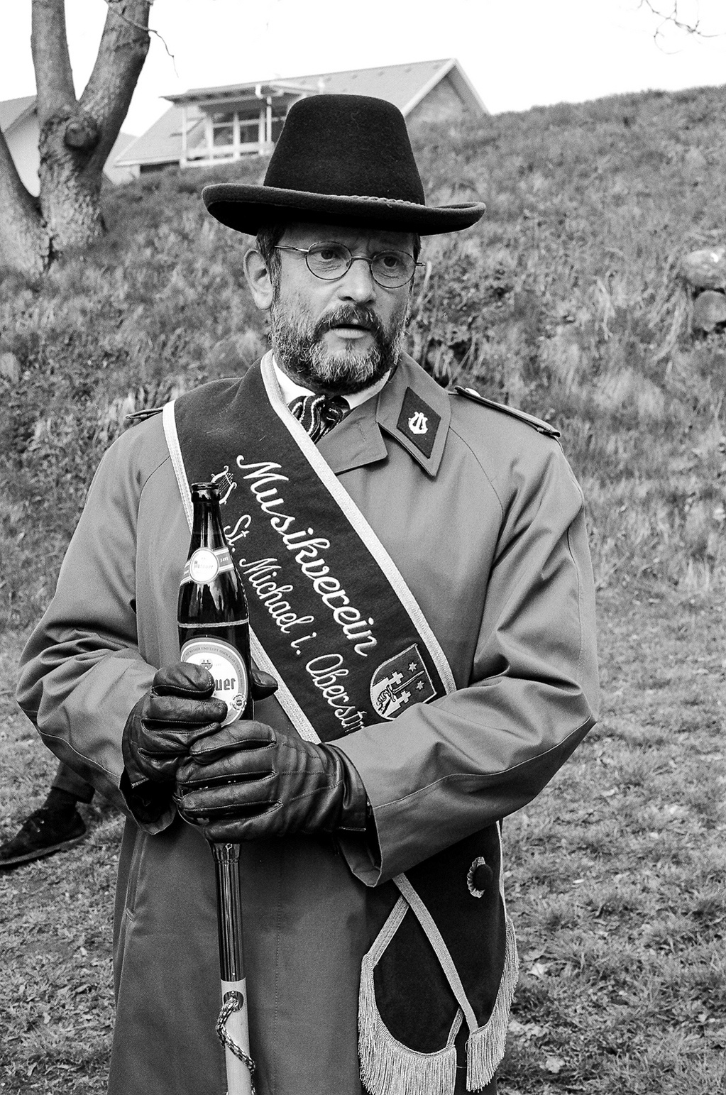 A black and white portrait of a man in uniform with a black hat who heads a music group during a traditional Easter procession in Styria, Austria.