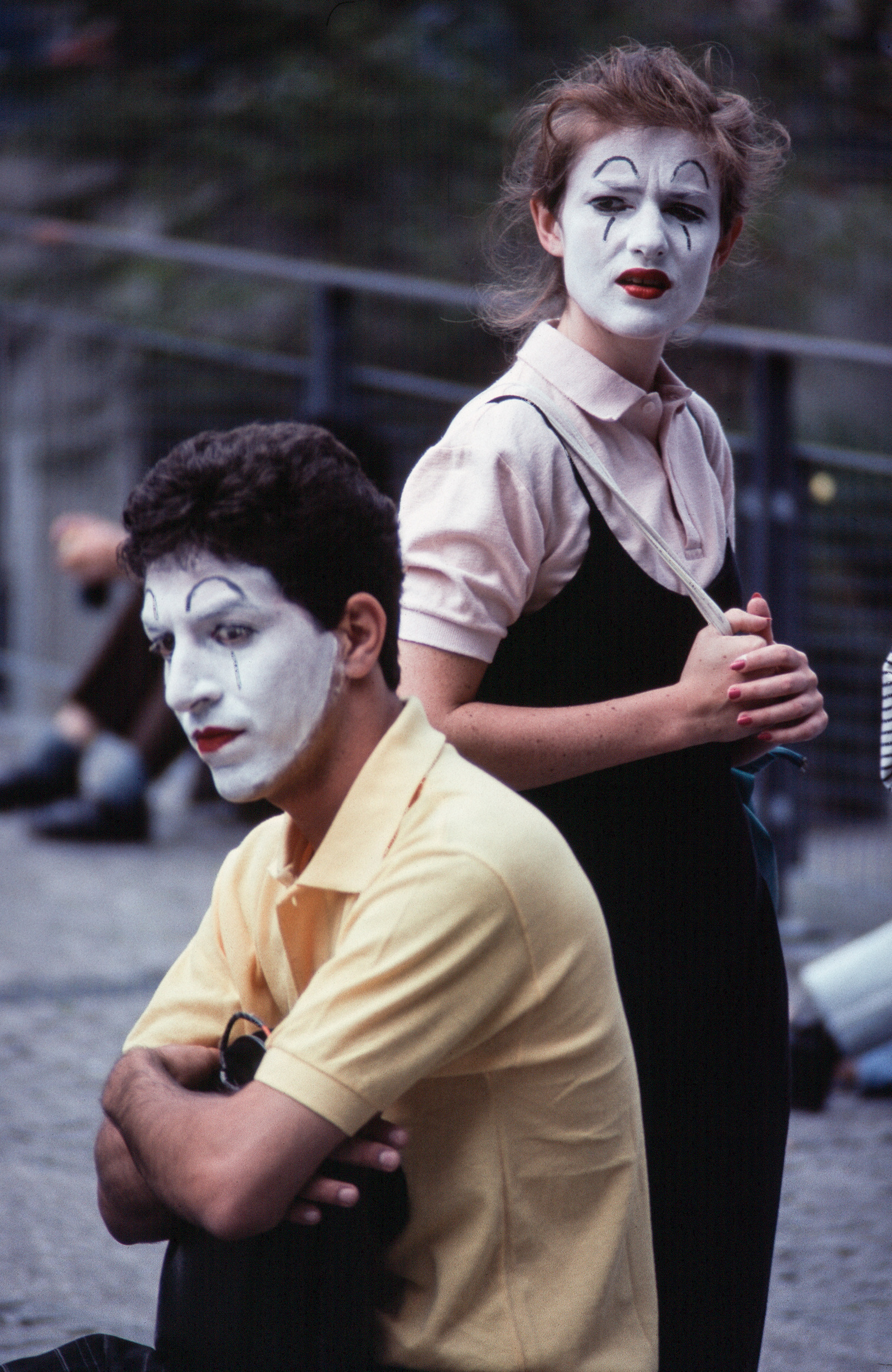 Two performers, a man and a woman with white painted faces, waiting. Paris, France.