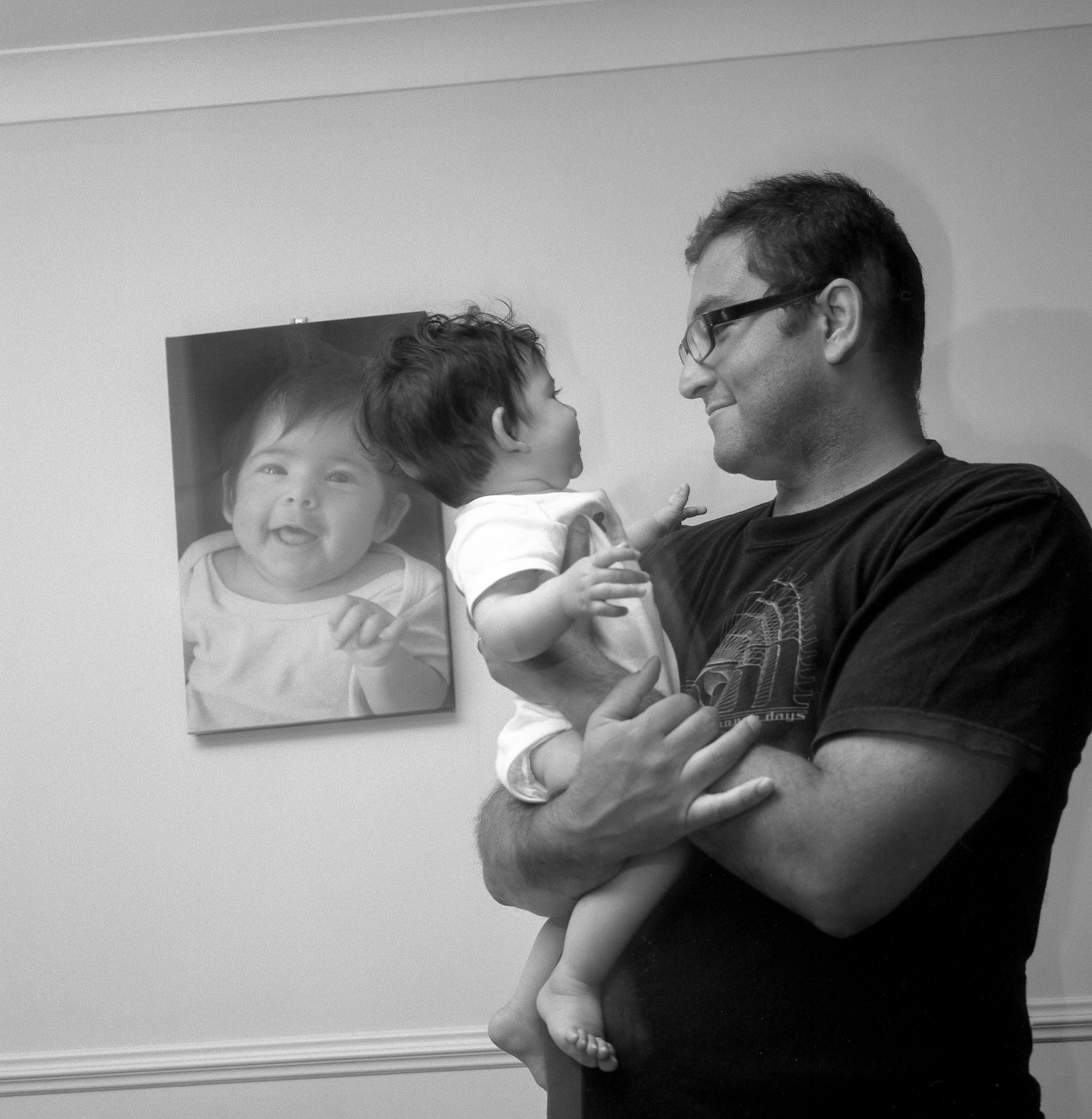 Black and white portrait of a man with a baby in his arms.