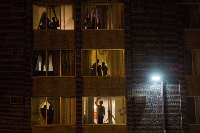 People watch protesters march down Franklin Ave. from the windows of their apartments in Minneapolis on Thursday, Nov. 10, 2016.