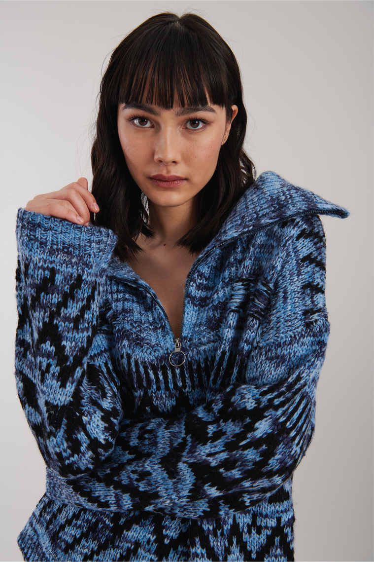 Girl wearing a blue and black sweater looking serious