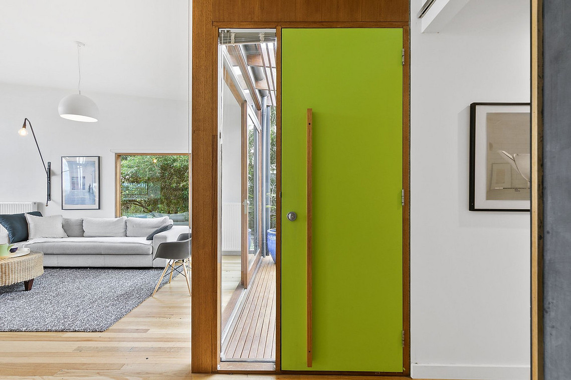  A hand made front door handle reduces the manufacturers miles of this simple item. The timber door handle contrasts with the bright green coloured front door
