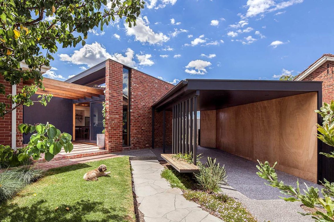 A Cavoodle puppy enjoys the afternoon sun in this upgraded home with a north facing courtyard featuring recycled red bricks.