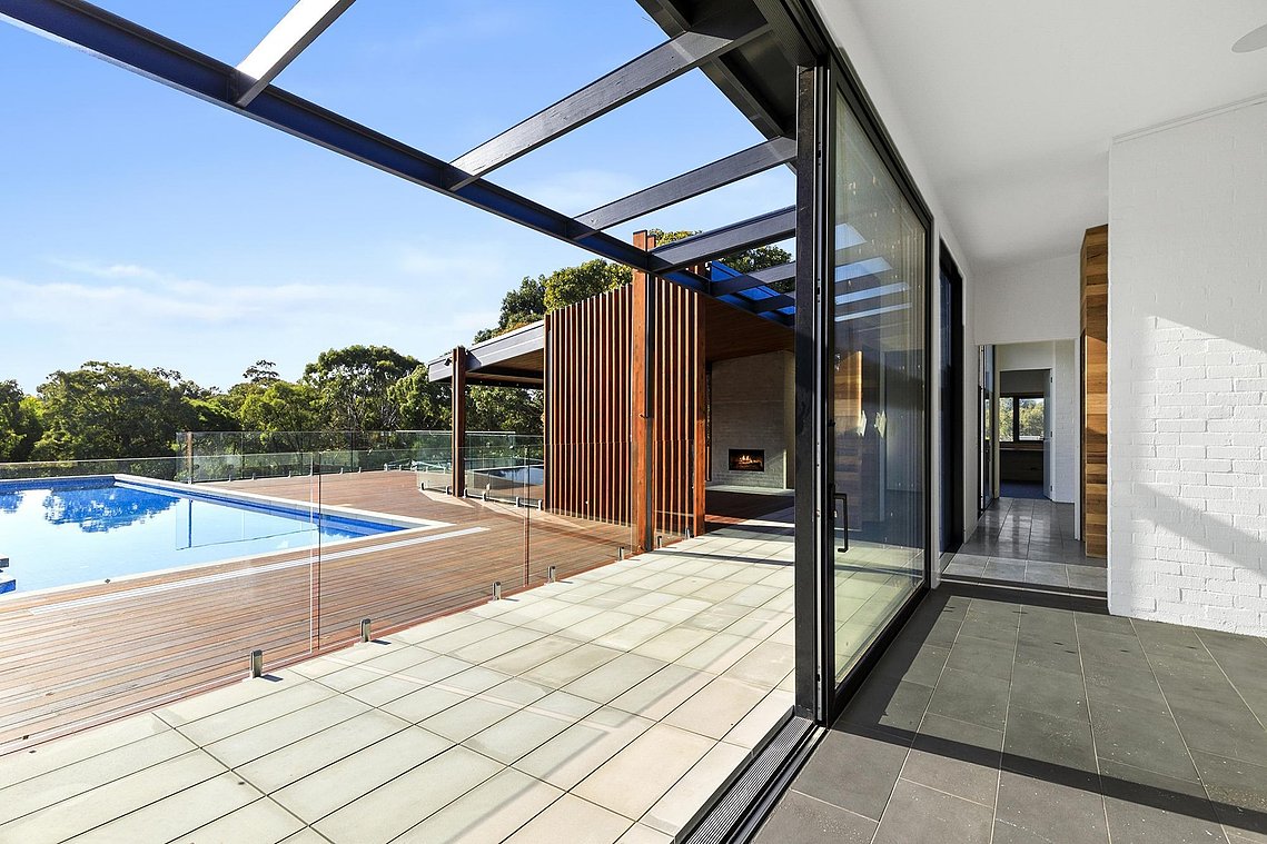 Indoor outdoor sustainable living in Torquay. Large thermally broken aluminium sliding doors open out to paved and decked pool area.