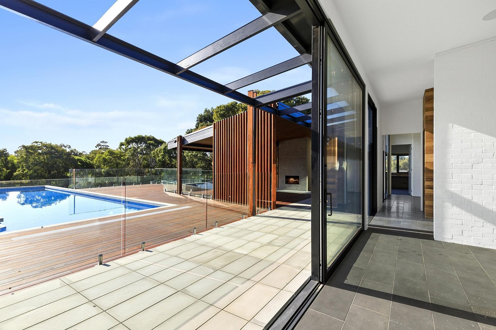 Indoor outdoor living is featured here with a living space opening out onto a large pool