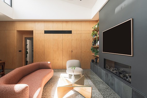 Cosy living space with modern chairs and glass table in a timber ply lined room.