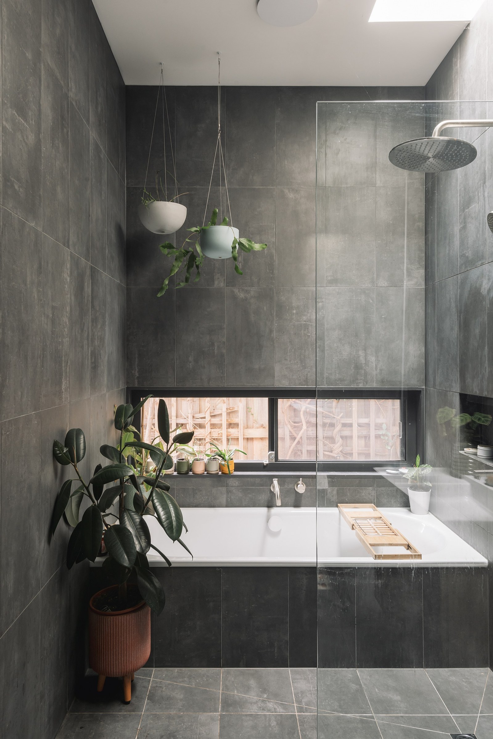 New shower and bath with indoor plants and skylight above