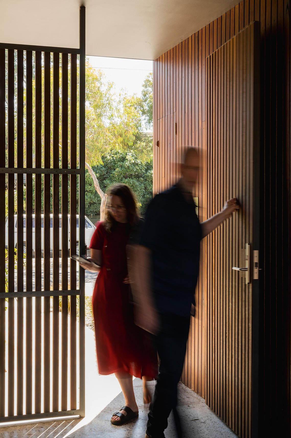 Two people entering through a front entryway off the street into a transition space. Sustainable design Brunswick