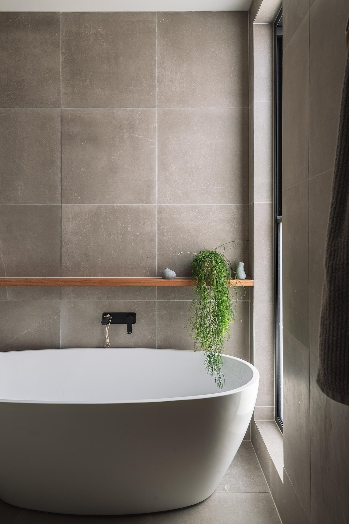 Simple modern bath adjacent to a window with light coming through. Sustainable living in Preston