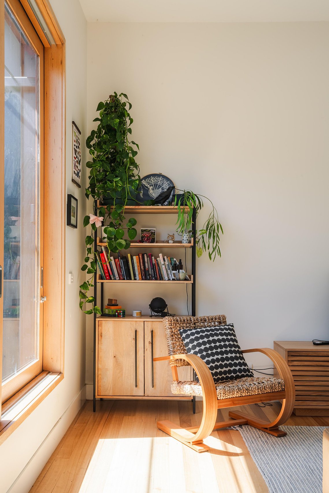 Sunny lounge room with large timber window and comfortable chair. Sustainable living in Preston
